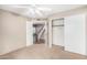 Neutral bedroom features a closet, a view to the stairs, a ceiling fan, and neutral-colored walls and carpet at 609 E Mesquite Cir # D131, Tempe, AZ 85288