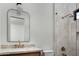 Bright bathroom featuring a sleek mirror, a glass-door shower, and a modern sink with brass fixtures and a stone countertop at 6312 E Calle Del Paisano --, Scottsdale, AZ 85251