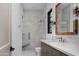 Modern bathroom with a herringbone-patterned shower, mosaic tile floor, and a vanity with a stone countertop and woven mirror at 6312 E Calle Del Paisano --, Scottsdale, AZ 85251