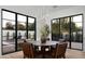 A modern dining room with black pane windows, a wooden table, and decorative plants at 6312 E Calle Del Paisano --, Scottsdale, AZ 85251