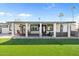 Wide shot of a green backyard featuring covered patio with dining and seating areas, against a blue sky at 6440 E Jean Dr, Scottsdale, AZ 85254