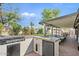 Backyard featuring an outdoor kitchen with a built-in grill, fridge, covered patio, and lush landscaping at 6440 E Jean Dr, Scottsdale, AZ 85254