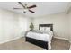 Neutral bedroom featuring a dark wood bed frame, soft gray carpet, ceiling fan, and a white door at 6440 E Jean Dr, Scottsdale, AZ 85254