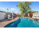 Stunning backyard pool with a fire pit, basketball hoop, and a brick-paved patio at 6440 E Jean Dr, Scottsdale, AZ 85254