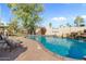 Beautiful backyard pool with rock waterfall, basketball hoop, mature trees and brick-paved patio at 6440 E Jean Dr, Scottsdale, AZ 85254