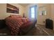 Cozy bedroom with a patterned bedspread, carpeted floor, and window providing natural light at 650 N Hawes Rd # 3827, Mesa, AZ 85207