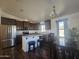 Well-lit kitchen featuring stainless steel appliances, dark cabinets, an island, and a dining table at 650 N Hawes Rd # 3827, Mesa, AZ 85207