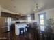 Bright kitchen featuring stainless steel appliances, dark cabinets, an island, and an adjacent dining space at 650 N Hawes Rd # 3827, Mesa, AZ 85207