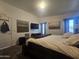 This main bedroom features a comfortable bed, art, television, and natural light at 650 N Hawes Rd # 3827, Mesa, AZ 85207