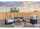 Outdoor living area with stone patio, furniture set, gas grill, and wooden fence at 6601 E Latham St, Scottsdale, AZ 85257