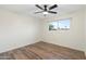 Empty bedroom with wood floors, a ceiling fan and a large window at 6601 E Latham St, Scottsdale, AZ 85257