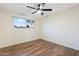 Bright bedroom featuring wood floors, ceiling fan, and a window providing ample natural light at 6601 E Latham St, Scottsdale, AZ 85257