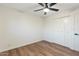 This bedroom includes wood floors, a ceiling fan, and a spacious closet for storage at 6601 E Latham St, Scottsdale, AZ 85257