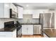 Modern kitchen with stainless steel appliances, granite countertops, and white cabinets at 6601 E Latham St, Scottsdale, AZ 85257