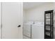 Well-lit laundry room with washer, dryer, and shelving for storage at 6601 E Latham St, Scottsdale, AZ 85257