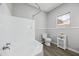 Bright bathroom featuring white tile shower and tub, new toilet and gray paint at 713 E Eason Ave, Buckeye, AZ 85326