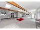 Large bonus room features a red rug, light wood ceiling beams and gray carpet at 713 E Eason Ave, Buckeye, AZ 85326