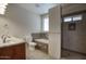 Bathroom featuring a double sink vanity, a soaking tub, and a separate tiled shower with a built-in niche at 725 W Hermosa Dr, Wickenburg, AZ 85390