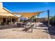 Covered patio with a dining table, swing chair, and shade at 7365 W Via Del Sol Dr, Glendale, AZ 85310