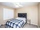 Cozy bedroom features a comfortable bed, window with shutters, and ceiling fan at 7365 W Via Del Sol Dr, Glendale, AZ 85310