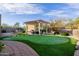 Expansive backyard featuring a patio, comfortable seating, putting green, and lush landscaping at 7952 E Teton Cir, Mesa, AZ 85207