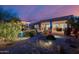 Evening shot of landscaped backyard with putting green, outdoor seating, and pergola at 7952 E Teton Cir, Mesa, AZ 85207