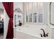 Close up on soaking tub with plantation shutters and decorative wrought iron candle holder at 7952 E Teton Cir, Mesa, AZ 85207