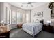 Cozy bedroom with ceiling fan, bed, shuttered windows, and neutral-toned walls at 7952 E Teton Cir, Mesa, AZ 85207