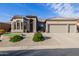 Charming home featuring a three-car garage and beautifully landscaped front yard at 7952 E Teton Cir, Mesa, AZ 85207