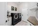 Well-lit laundry room with front-load washer and dryer, sink, and storage cabinets at 7952 E Teton Cir, Mesa, AZ 85207