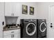 Bright laundry room featuring a sink, cabinets, front-load washer/dryer and painted walls at 7952 E Teton Cir, Mesa, AZ 85207