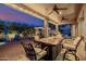 Covered patio featuring a fire table with seating and a view of the beautifully landscaped backyard at 7952 E Teton Cir, Mesa, AZ 85207