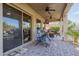 Covered outdoor patio with ceiling fans, a TV, and comfortable seating with views of the yard at 7952 E Teton Cir, Mesa, AZ 85207