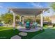 Charming covered pergola featuring comfortable seating and lush landscaping, perfect for relaxation and outdoor enjoyment at 7952 E Teton Cir, Mesa, AZ 85207