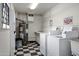 Clean laundry room featuring two washing machines, a water heater, and checkered tile flooring at 815 N Hayden Rd # B109, Scottsdale, AZ 85257