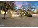 Rear view of home showcasing the large backyard with desert landscaping, a spiral staircase, and covered patio at 8254 E Juan Tabo Rd, Scottsdale, AZ 85255