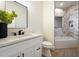 Bathroom with a white vanity, decorative mirror, and tiled shower and tub surround at 8254 E Juan Tabo Rd, Scottsdale, AZ 85255