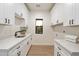 Bright laundry room with white cabinets, a utility sink, and views to the outside at 8254 E Juan Tabo Rd, Scottsdale, AZ 85255