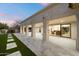 Covered patio with stone flooring, manicured lawn, and access to the home's interior through sliding glass doors at 8254 E Juan Tabo Rd, Scottsdale, AZ 85255