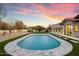 Scenic backyard pool with water features, stone patio, and a manicured lawn set against a picturesque sunset at 8254 E Juan Tabo Rd, Scottsdale, AZ 85255