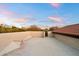 Rooftop patio area with a low stucco wall, tile roofing, and panoramic views of the desert landscape at 8254 E Juan Tabo Rd, Scottsdale, AZ 85255