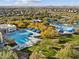 Aerial view of a community pool and splashpad area that offers refreshing fun for all ages with ample seating at 8506 W Trenton Ct, Florence, AZ 85132