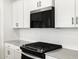 Modern kitchen with stainless steel microwave, white cabinetry, grey countertops and stylish backsplash at 8555 W Trenton Ct, Florence, AZ 85132