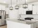 Bright kitchen features white cabinetry, stainless steel appliances, and a large island with granite countertops at 8555 W Trenton Ct, Florence, AZ 85132