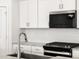 Close-up of a kitchen featuring stainless steel appliances, white cabinetry, and a stylish backsplash at 8555 W Trenton Ct, Florence, AZ 85132