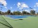 Community tennis courts with blue surfaces, green surround, black fencing, tall lights and covered gazebo at 8560 W Trenton Ct, Florence, AZ 85132