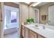 Bright bathroom featuring vanity lighting, a bathtub with shower, and a large mirror at 9372 E Aster Dr, Scottsdale, AZ 85260