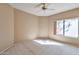 Cozy bedroom with a ceiling fan, neutral walls, and a large window bringing in natural light at 9372 E Aster Dr, Scottsdale, AZ 85260