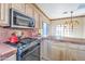 Close-up of kitchen featuring modern stainless steel appliances, tiled countertops, and ample storage at 9372 E Aster Dr, Scottsdale, AZ 85260