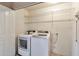 Bright laundry room featuring a modern washer and dryer set with wire shelving above for storage at 9372 E Aster Dr, Scottsdale, AZ 85260